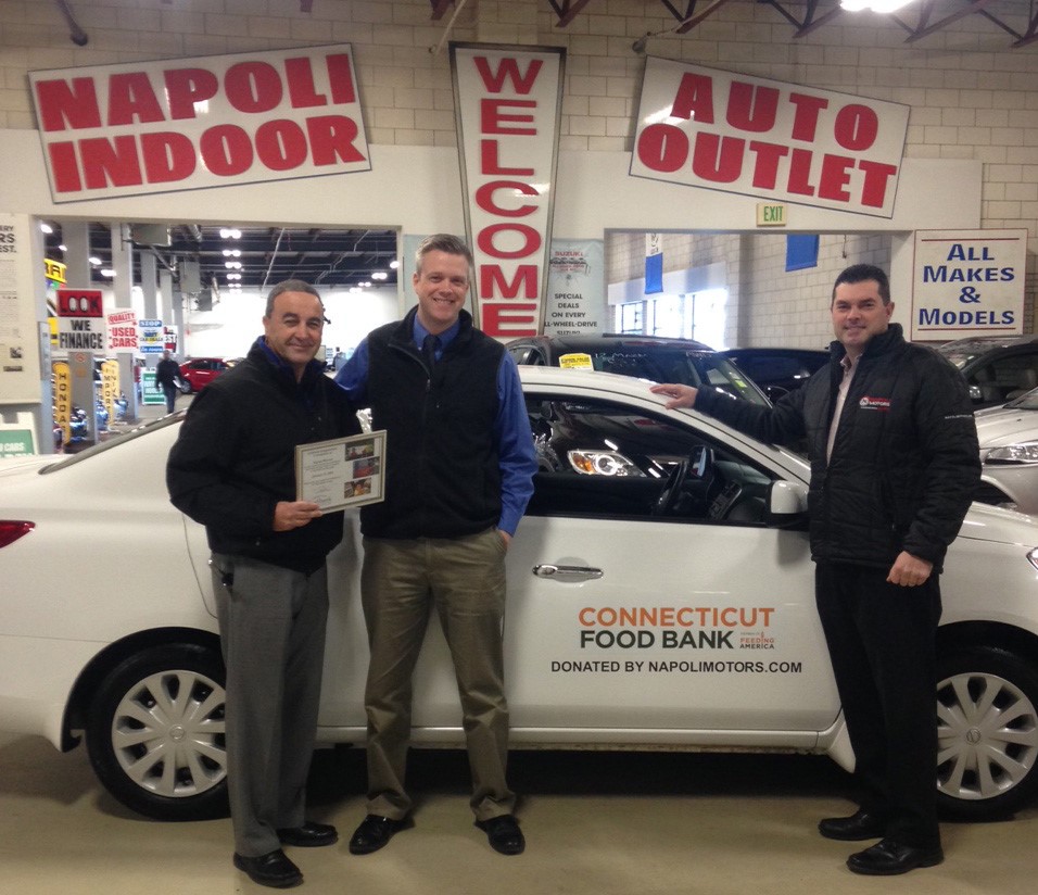 Napoli Motors presented a 2014 Nissan Versa to the Connecticut Food Bank. Pictured at the Napoli Indoor Auto Outlet are, left to right: Mr. Leonard Napoli Jr, Owner, Napoli Motors, Michael Davidow, Corporate Development Officer for the Connecticut Food Bank, and Scott Haverl, General Manager, Napoli Motors.
