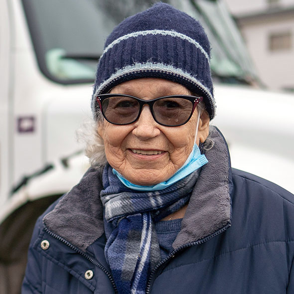 An elderly Hispanic woman getting food assistance from a Connecticut Foodshare mobile food pantry.